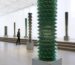 a person looks at several towering sculptures made of cds